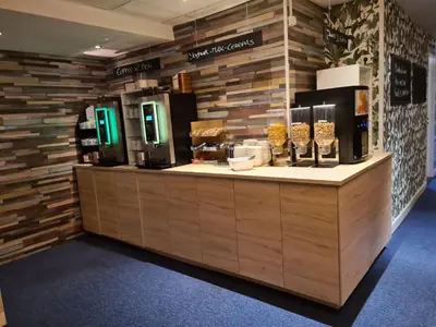 a coffee shop with a counter with food on it at Amsterdam Hotel Uithoorn in Uithoorn