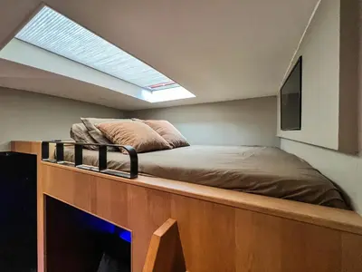 a bedroom with a bed and a skylight at Boat & Boost Amsterdam in Amsterdam