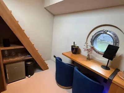 a room with blue chairs and a table and a mirror at Boat & Boost Amsterdam in Amsterdam