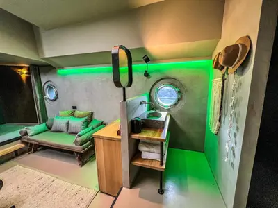 a green room with a couch and a table at Boat & Boost Amsterdam in Amsterdam