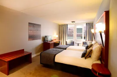 a hotel room with a bed and a desk at Hotel Zuiderduin in Egmond aan Zee