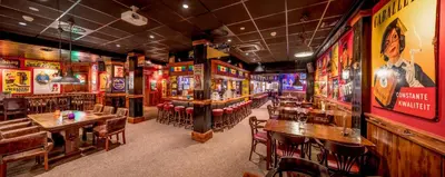 a bar with tables and chairs in a restaurant at Hotel Zuiderduin in Egmond aan Zee