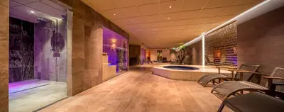 a large bathroom with a tub and a table and chairs at Hotel Zuiderduin in Egmond aan Zee