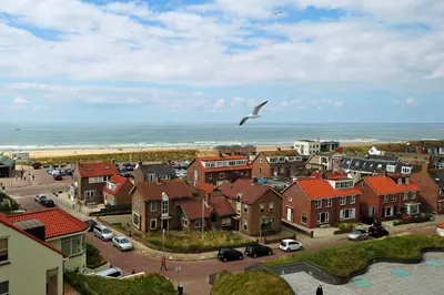 a bird flying over a town with houses and the ocean at Hotel Zuiderduin in Egmond aan Zee