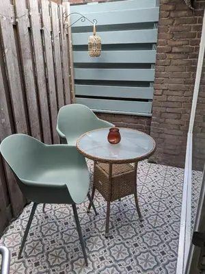 two chairs and a table on a patio at zomerhuis in Wijk aan Zee! 2 pers in Wijk aan Zee