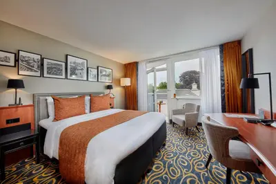 a hotel room with a bed and a desk and a window at Carlton Square Hotel in Haarlem