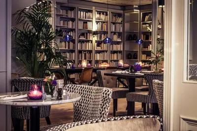 a restaurant with tables and chairs and books at Carlton Square Hotel in Haarlem
