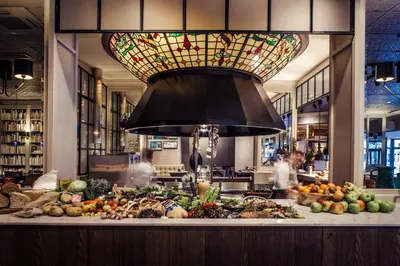 a large chandelier above a counter with fruits and vegetables at Carlton Square Hotel in Haarlem