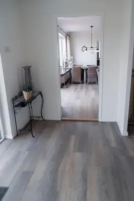 a living room with a hard wood floor and a dining room at Vakantiebungalow Limmen in Limmen
