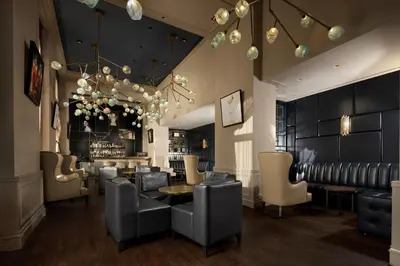 a restaurant with chairs and a table and a bar at InterContinental Amstel Amsterdam by IHG in Amsterdam