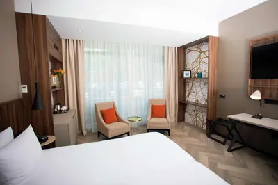 a hotel room with a bed and two chairs at DoubleTree by Hilton Royal Parc Soestduinen in Amersfoort