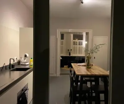 a kitchen with a table with chairs and a kitchen with a counter at B&B Vechtzicht in Weesp