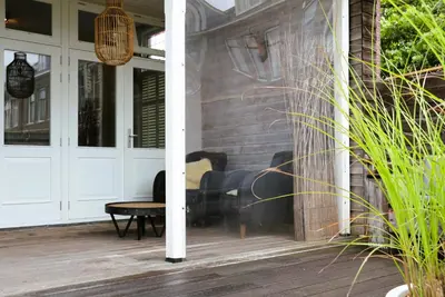 a screened porch with a table on a house at B&B Vechtzicht in Weesp