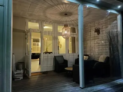 a living room with a couch and chairs and a chandelier at B&B Vechtzicht in Weesp