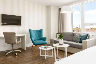 a living room with a couch and chairs and a table at NH Utrecht in Utrecht