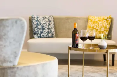 a living room with a table with wine glasses and a couch at NH Utrecht in Utrecht