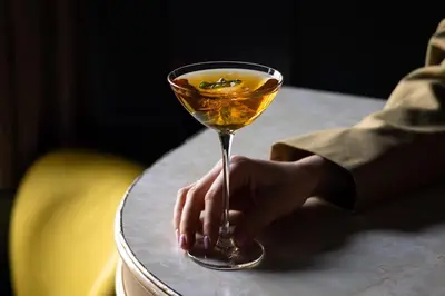 a person holding a glass of wine on a table at Kimpton De Witt Amsterdam by IHG in Amsterdam