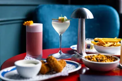 a red table topped with plates of food and a drink at Kimpton De Witt Amsterdam by IHG in Amsterdam