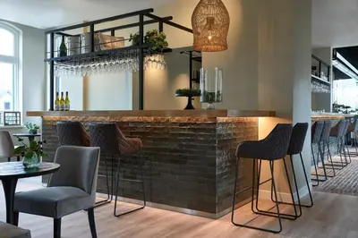 a bar in a restaurant with chairs and tables at Brasserie Spoorhuis Mijdrecht in Mijdrecht