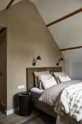 a bedroom with a bed with two lights on the wall at Brasserie Spoorhuis Mijdrecht in Mijdrecht