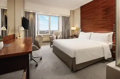 a hotel room with a large bed and a desk at Hotel Okura Amsterdam – The Leading Hotels of the World in Amsterdam
