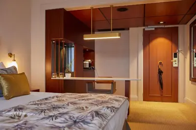 a hotel room with a bed and a kitchen at Hotel Okura Amsterdam – The Leading Hotels of the World in Amsterdam