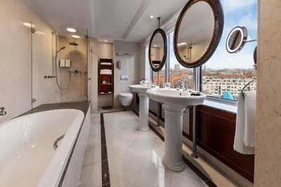 a bathroom with two sinks and a tub and a large mirror at Hotel Okura Amsterdam – The Leading Hotels of the World in Amsterdam