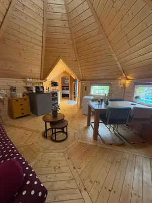 a room with a table and a kitchen in a cabin at Finse Kota met privé Sauna en Hottub in Spanbroek
