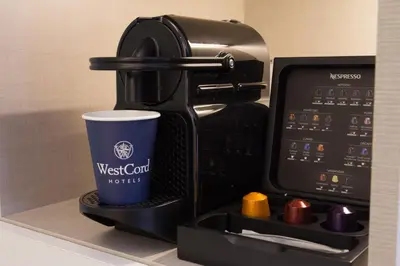 a coffeemaker with a coffee cup on a shelf at WestCord Art Hotel Amsterdam 3 stars in Amsterdam