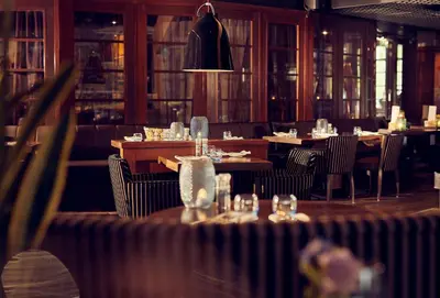 a restaurant with tables and chairs and a chandelier at WestCord Art Hotel Amsterdam 3 stars in Amsterdam