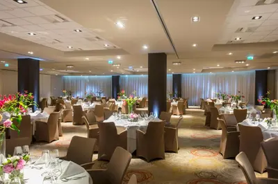a ballroom with tables and chairs in a room at Holiday Inn Amsterdam - Arena Towers by IHG in Amsterdam