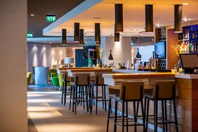 a bar in a restaurant with stools at Holiday Inn Amsterdam - Arena Towers by IHG in Amsterdam