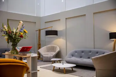 a living room with two chairs and a couch and a table at Holiday Inn Amsterdam - Arena Towers by IHG in Amsterdam