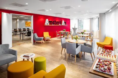 a restaurant with tables and chairs and a red wall at Holiday Inn Amsterdam - Arena Towers by IHG in Amsterdam