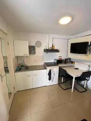 a small kitchen with a table and a desk at La Luna - Desi in Heerhugowaard
