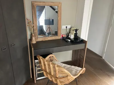 a dressing table with a mirror and a wicker chair at Villa Zandvoort in Zandvoort