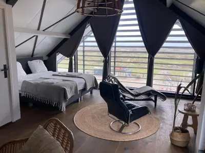 a bedroom with a bed and a chair at Villa Zandvoort in Zandvoort