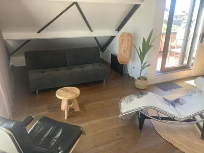 a living room with a black couch and chairs at Villa Zandvoort in Zandvoort