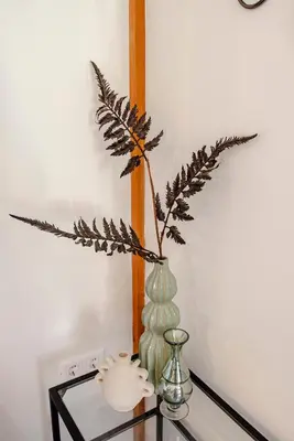 a vase with a plant in it on a glass table at Bed and Beach Zandvoort in Zandvoort