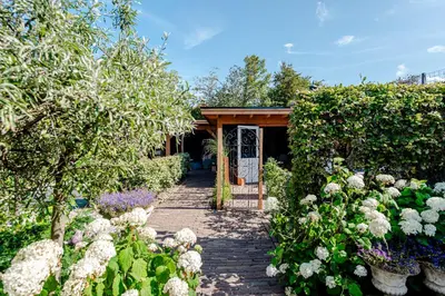 a garden with a pathway with flowers and a pavilion at Bed and Beach Zandvoort in Zandvoort