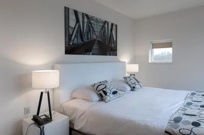 a bedroom with a white bed with a picture on the wall at Hotel Mitland in Utrecht