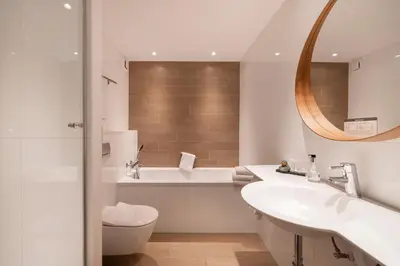 a bathroom with a sink and a toilet and a mirror at Hotel Mitland in Utrecht