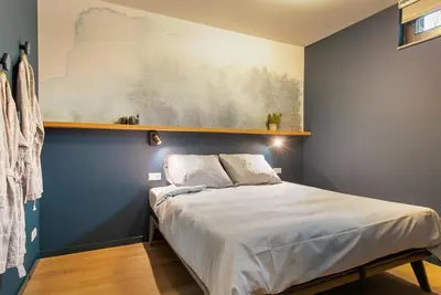 a bedroom with a bed with a blue wall at Waterlinie Lodges in Utrecht