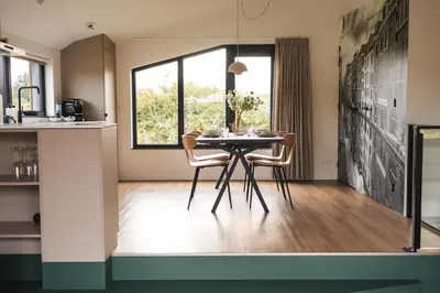 a kitchen and dining room with a table and chairs at Waterlinie Lodges in Utrecht