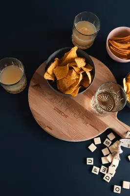 a bowl of tortilla chips on a wooden cutting board at Waterlinie Lodges in Utrecht