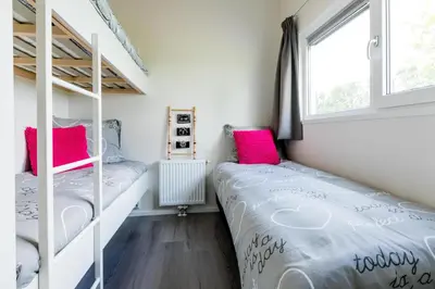 two bunk beds in a small room with a window at Park Westerkogge in Berkhout