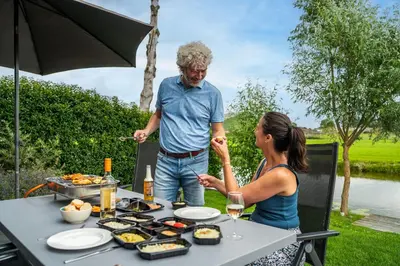 a man and a woman sitting at a table with food at Park Westerkogge in Berkhout