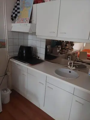 a kitchen with white cabinets and a sink at Mooi uitzicht appartement te huur tijdens de GP in Zandvoort in Zandvoort