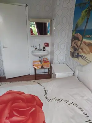 a bedroom with a white bed and a sink at Mooi uitzicht appartement te huur tijdens de GP in Zandvoort in Zandvoort