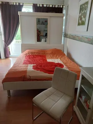 a bedroom with a bed and a chair in it at Mooi uitzicht appartement te huur tijdens de GP in Zandvoort in Zandvoort